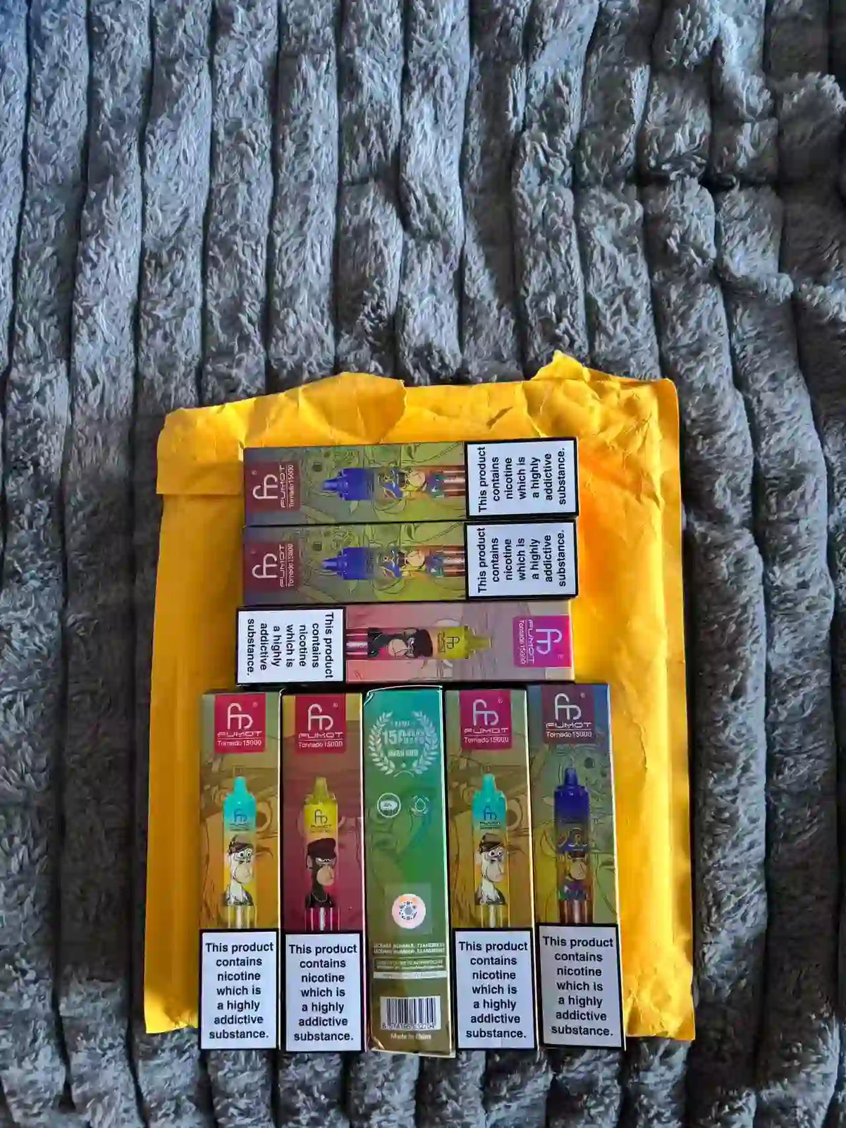 8 RandM Vapes auf gelber Verpackung liegend.