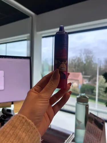 Mitarbeitern hält RandM Fumot Vape der Variante 15000 während der Arbeit in der Hand